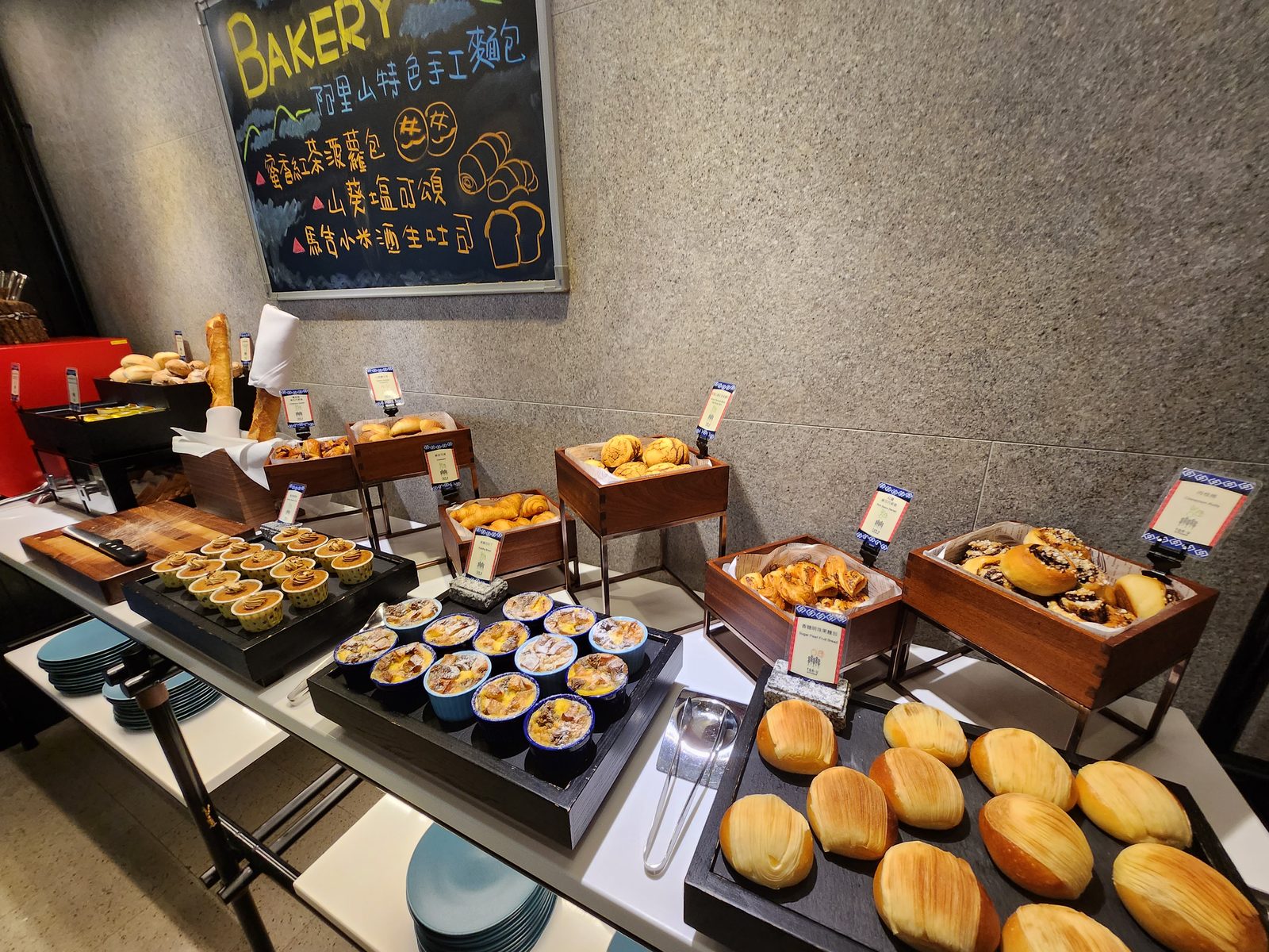 早餐麵包區的手寫黑板,寫著阿里山特色手工麵包與當日品項,後方木架陳列各式麵包