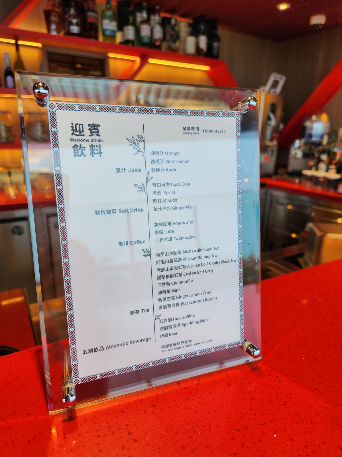 吧檯上的迎賓飲料菜單牌,列出果汁、軟性飲料、咖啡與阿里山茶品