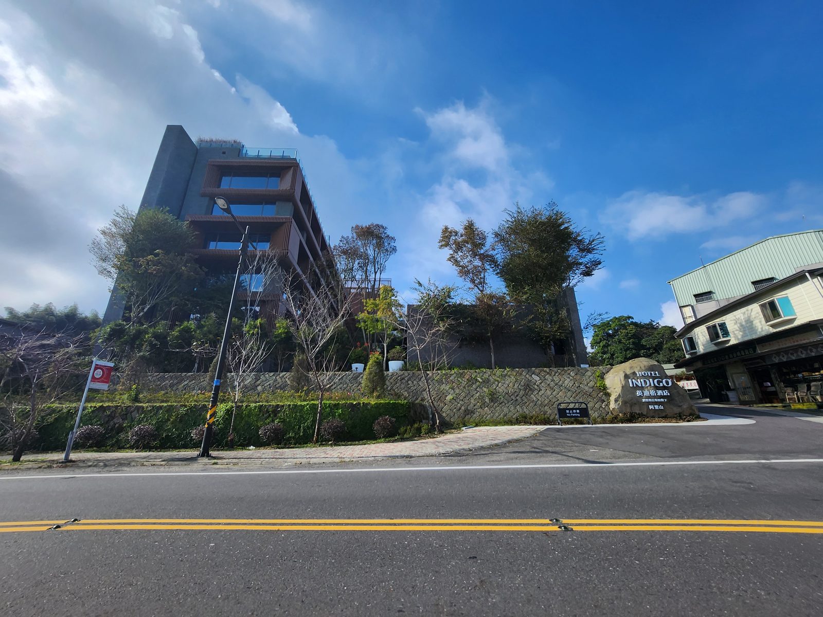 阿里山英迪格酒店的建築外觀與路邊刻有酒店名稱的巨石招牌